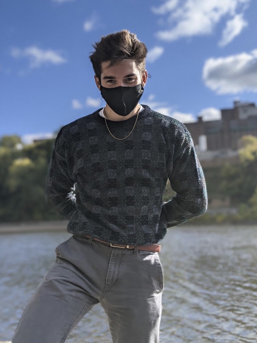Alex wearing a mask and a stylish sweater