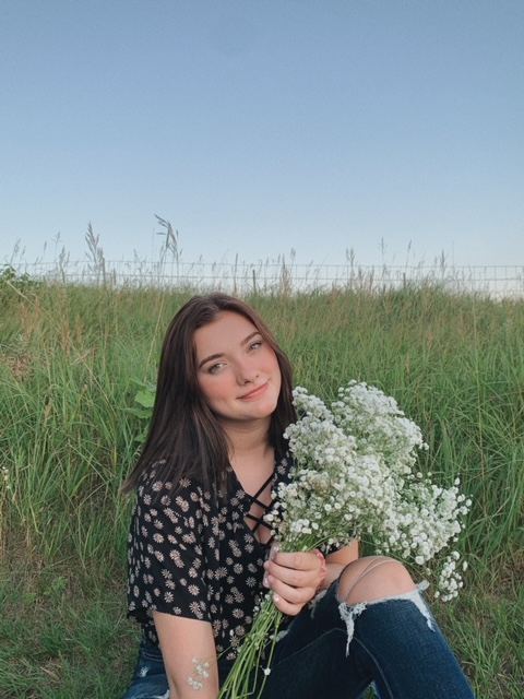 Ellie with some flowers in a field